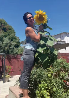 Denise Zellmann with a sunflower in a garden